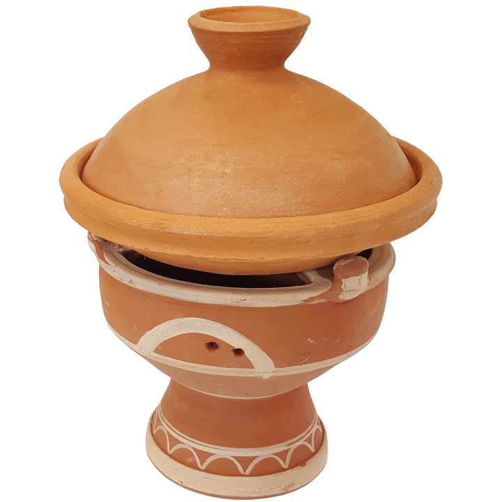 Tajine op een Marokkaanse kleiwarmer, mejmar voor houtskool als tafelgrill voor Tagine in Marokko-stijl