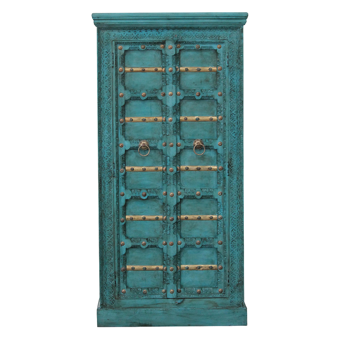 Vooraanzicht van de turquoise mangohouten kast met twee deuren, gesneden ornamenten en goudkleurige lijsten.