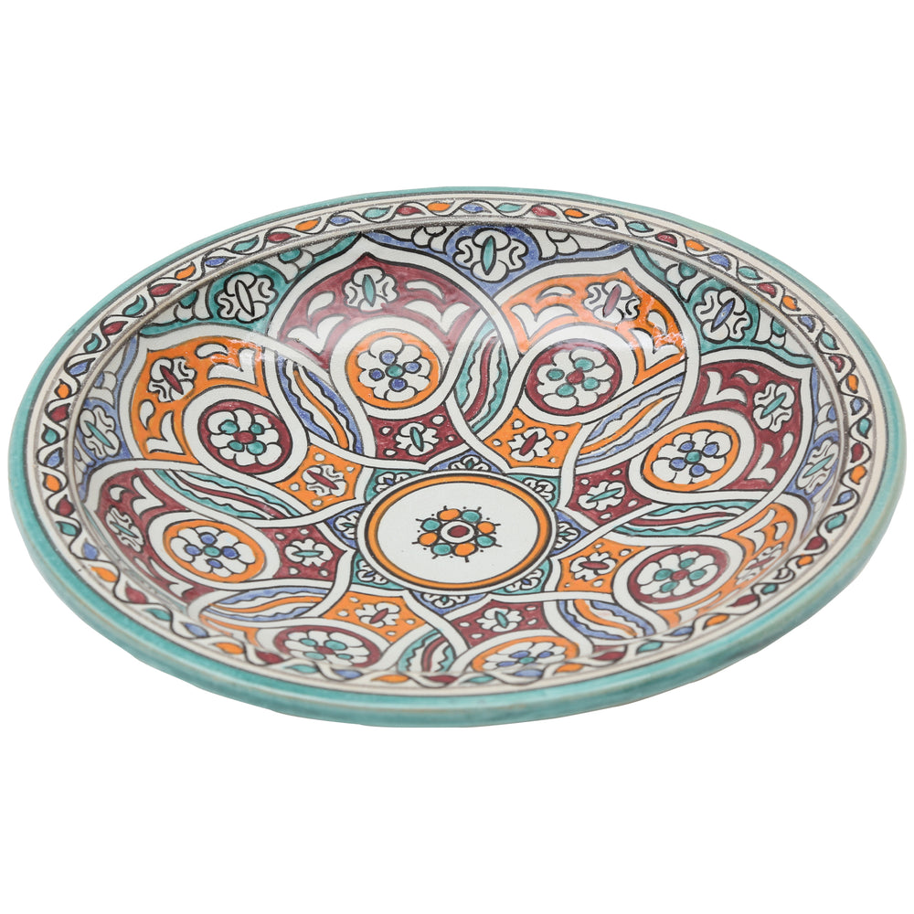Handgeschilderde keramische schaal met een verstrengeld cirkelmotief in turkoois, oranje en bordeauxrood