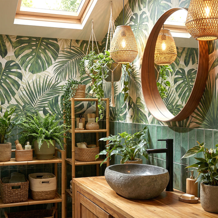 Rivierstenen aanrechtbassin in groene spabadkamer op houten wastafelmeubel, gecombineerd met zwarte fittingen en plantenambiance