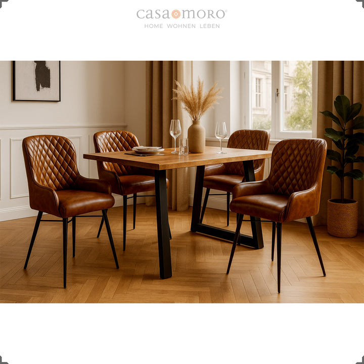Vier antikbraune Lederstühle mit Rautensteppung an einem Holztisch in elegantem Esszimmer mit Parkettboden, heller Wandverkleidung und natürlicher Dekoration.