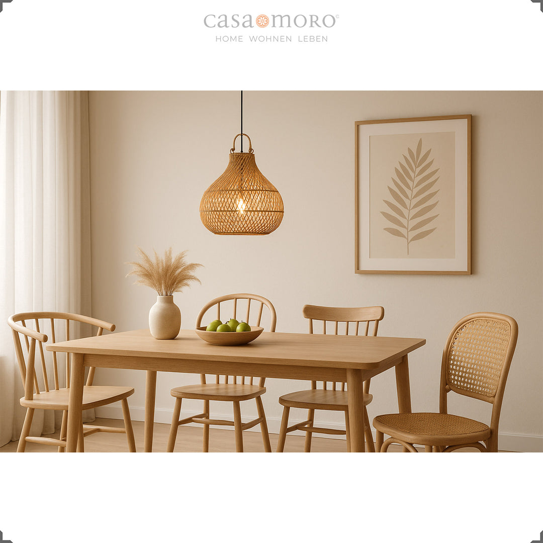 Hängende Rattanlampe über Esstisch im hellen Esszimmer mit natürlicher Dekoration und warmem Licht