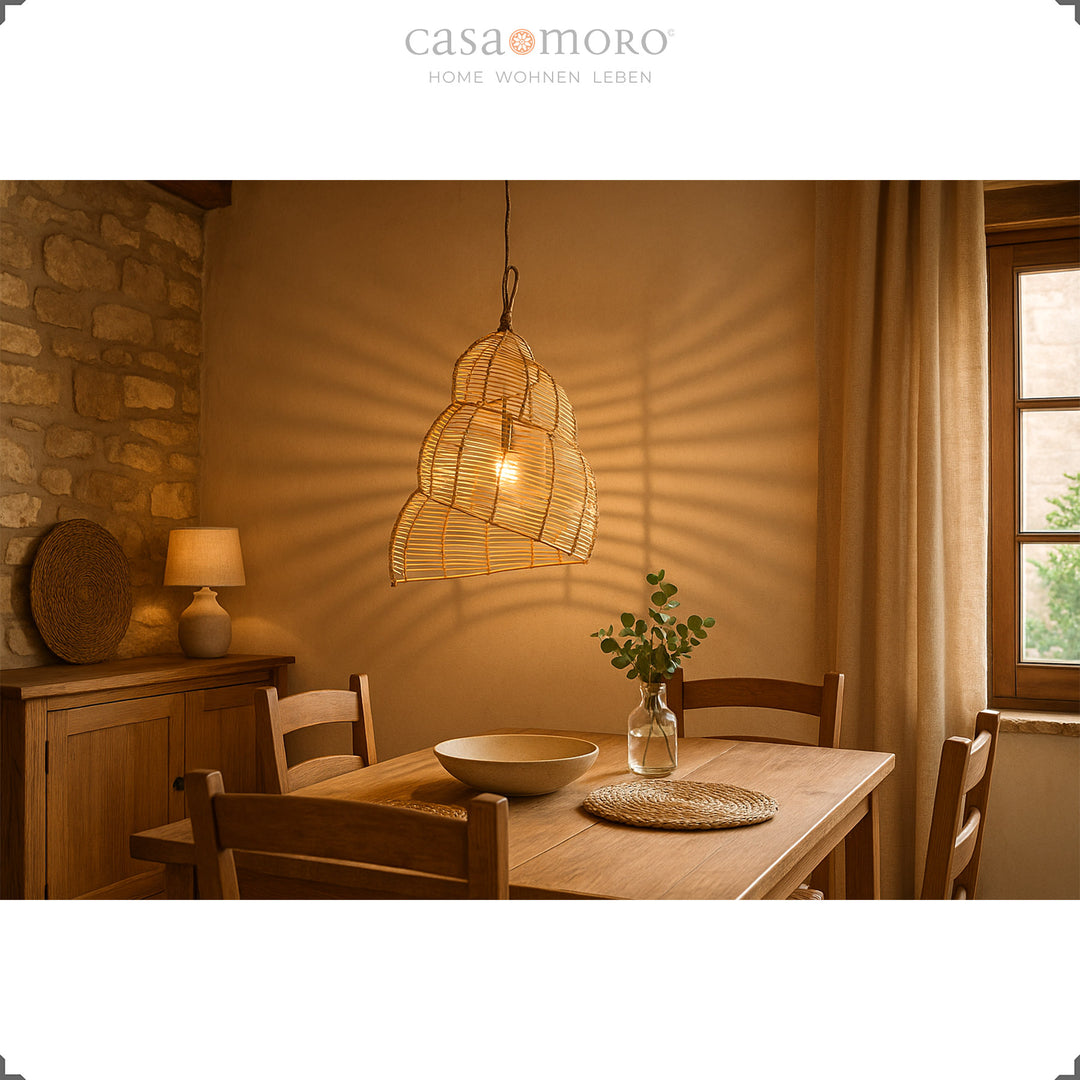 Handgefertigte Rattan-Lampe über einem Holztisch im Esszimmer, erzeugt warmes Licht und natürliche Atmosphäre