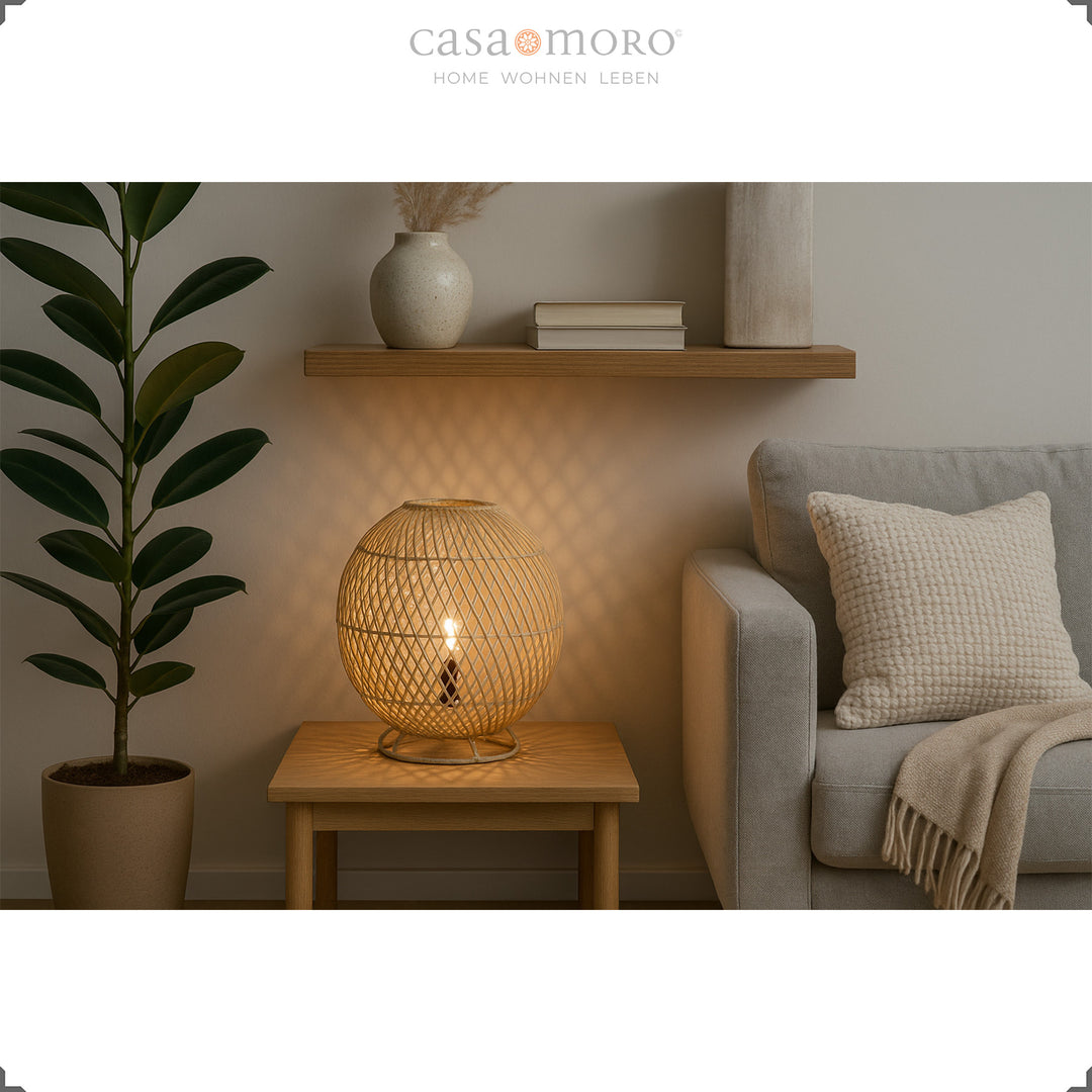 Runde Rattanlampe auf Holztisch neben Sofa, sanftes Licht und natürliche Einrichtung