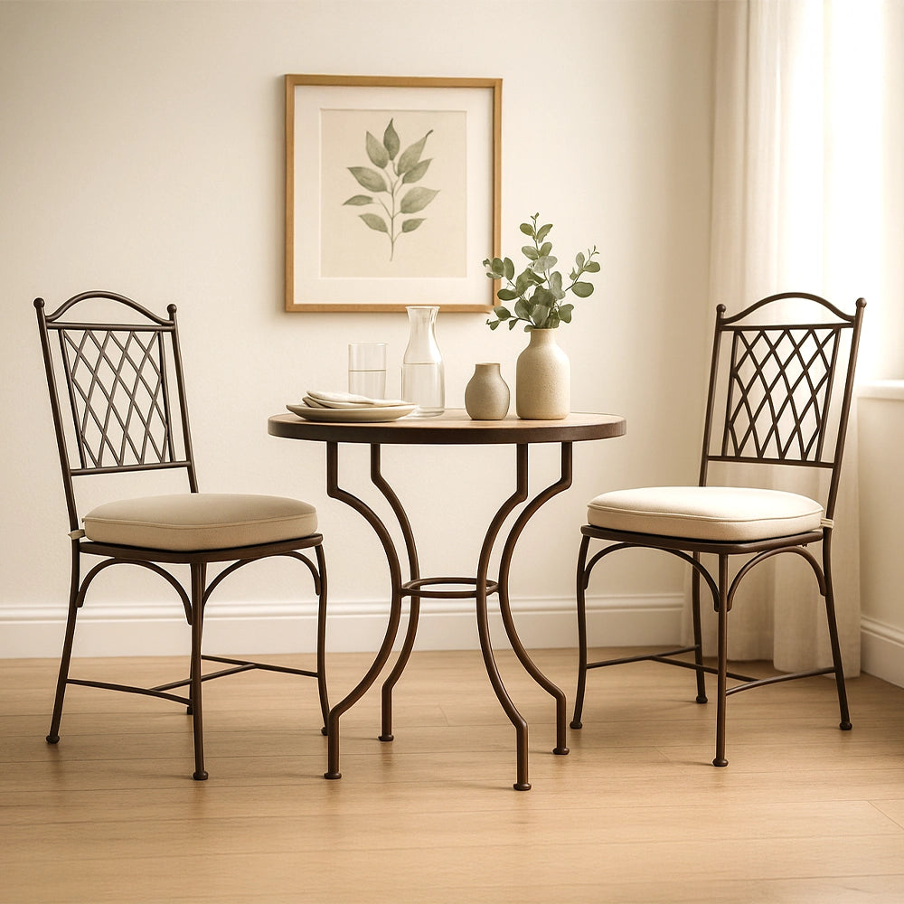 Helles Esszimmer mit rundem Metalltisch und zwei Stühlen mit Polster, dekoriert mit Keramikvasen und sanftem Tageslicht.